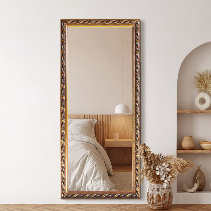 Decorative full-length mirror with ornate gold frame in a room setting.