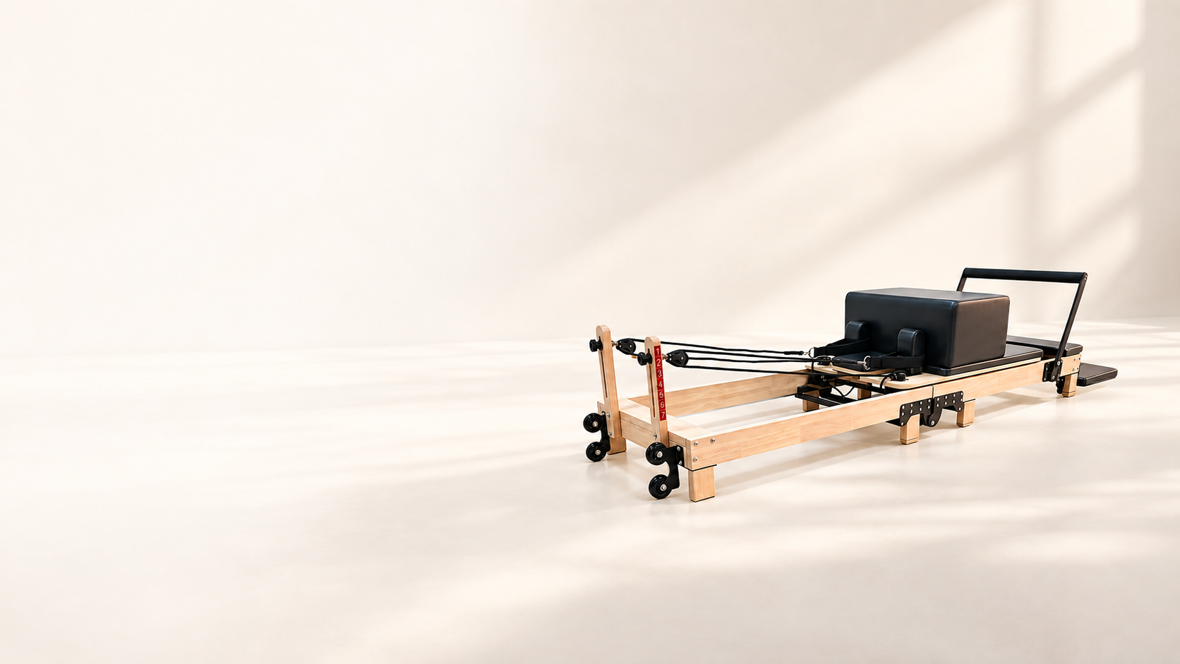 Foldable Oak Pilates Reformer in a warm, calm studio
